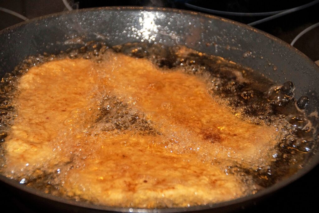 pork frying in pan of cooking oil - can you compost cooking oil